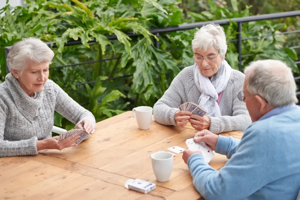Seniors playing cards in courtyard